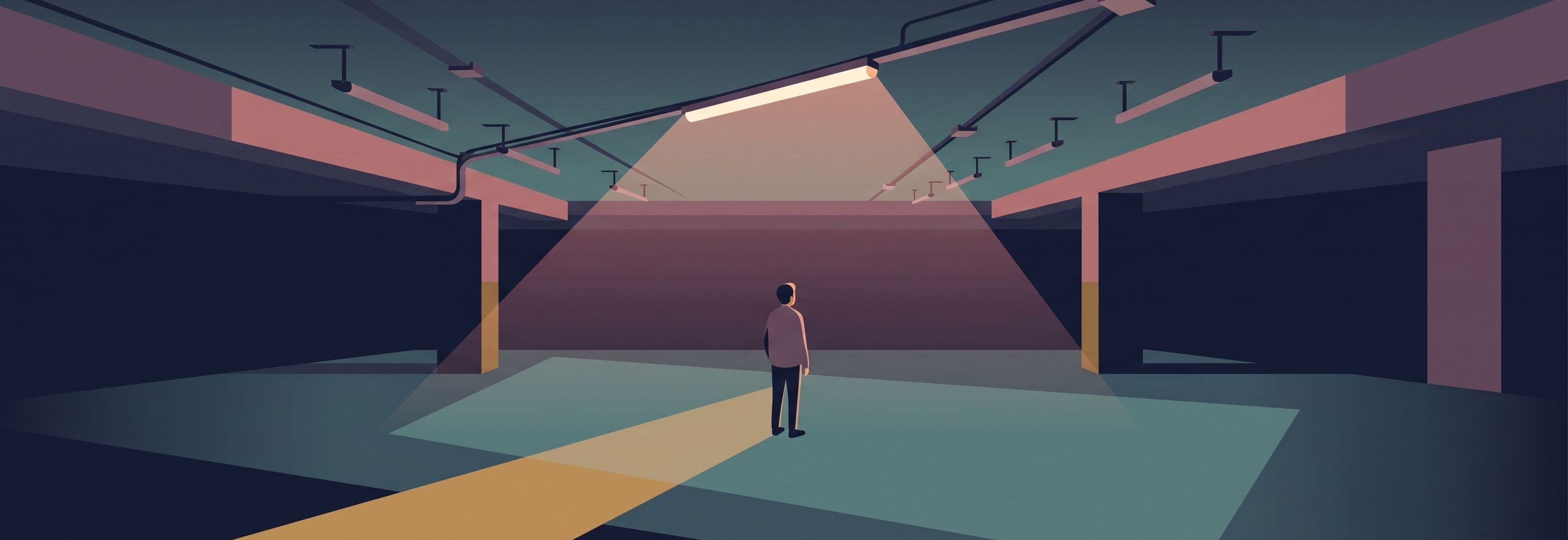 Solitary figure under one strip light in empty car park. Ceiling shows empty mounting points where identical lights should be